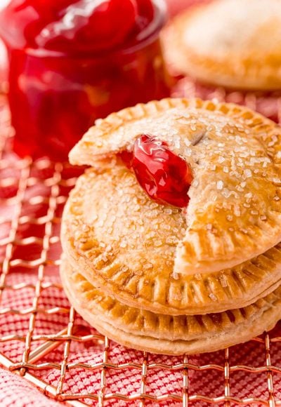 Close up photo of cherry hand pies on a copper wire rack.