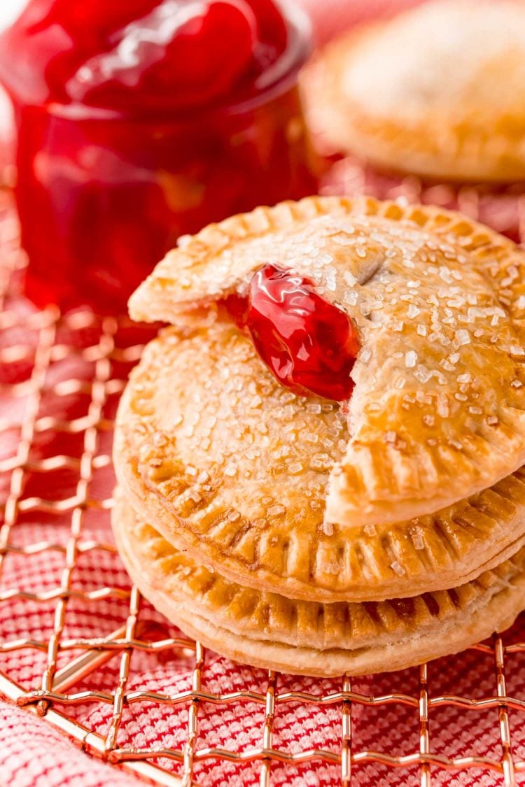 Close up photo of cherry hand pies on a copper wire rack.