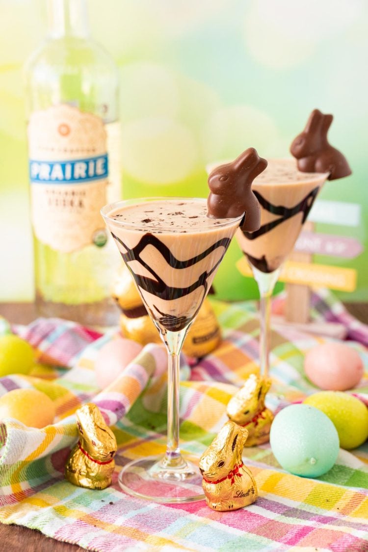 Two martini glasses with chocolate cocktails in them garnished with chocolate Easter bunnies.