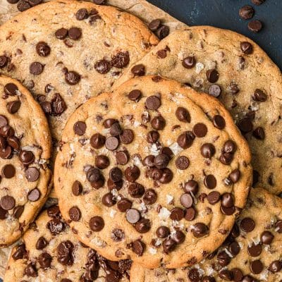 Giant chocolate chip cookies piled on a serving tray.