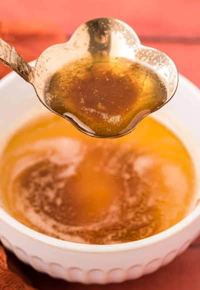 Brown butter being ladled out of a bowl.