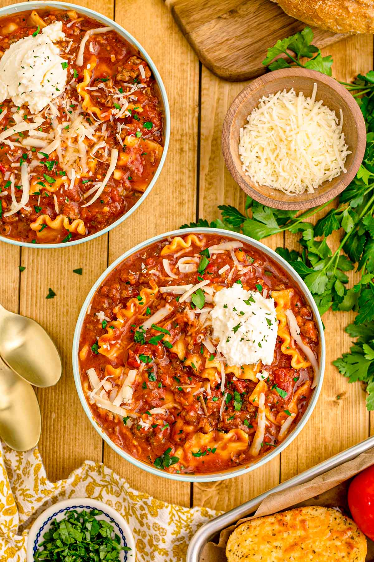 Overhead photos of bowls of lasagna soup on a wooden table.
