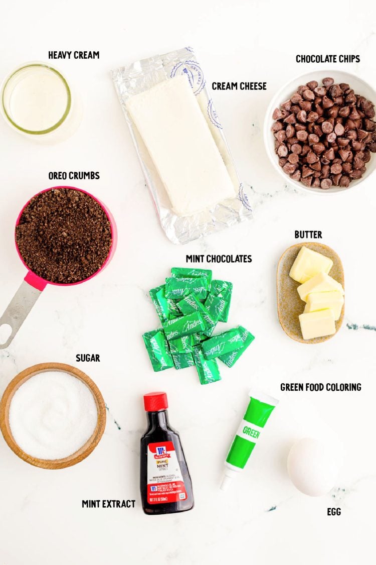 Ingredients to make mint chocolate cheesecakes on a marble surface.