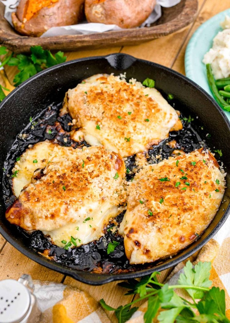 A cast iron skillet with Parmesan Crusted Chicken in it.