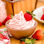 Strawberry buttercream frosting in a wooden bowl.