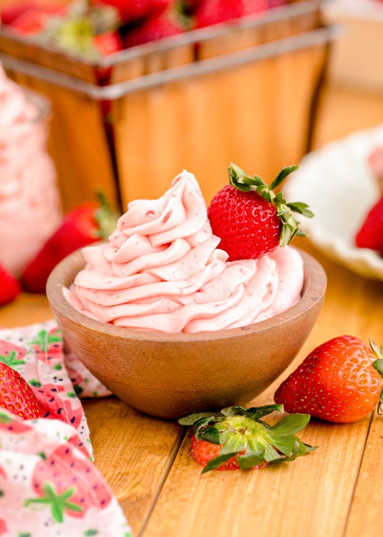 Strawberry buttercream frosting in a wooden bowl.