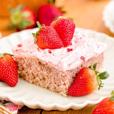 Close up photo of a slice of strawberry sheet cake on a plate.