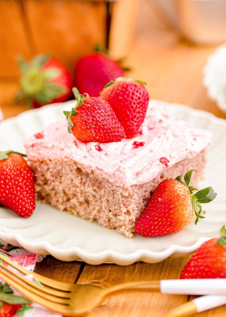 Close up photo of a slice of strawberry sheet cake on a plate.