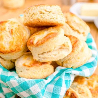 Close up photo of buttermilk biscuits in a teal and white checkered napkin.