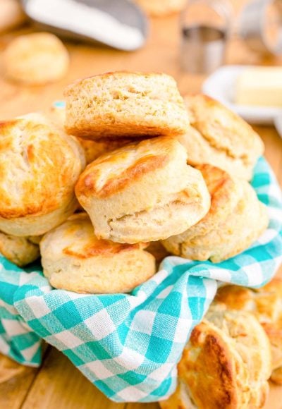 Close up photo of buttermilk biscuits in a teal and white checkered napkin.