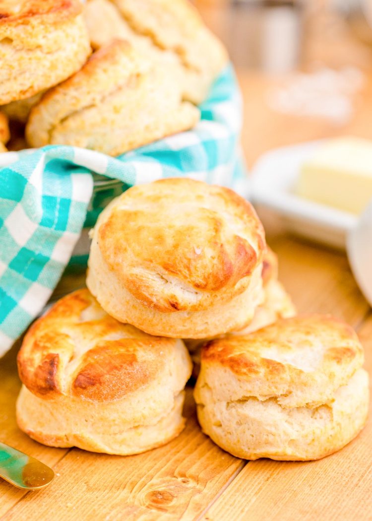 Buttermilk biscuits on a wooden table with a teal and white napkin.