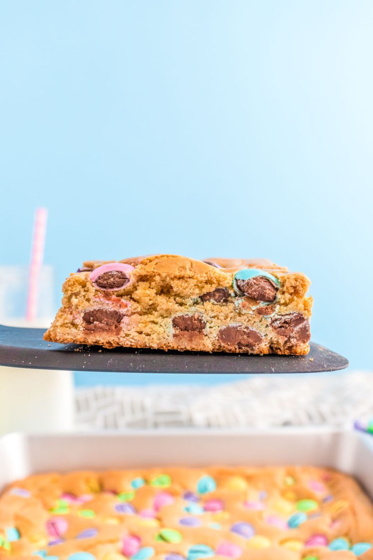 A slice of Easter blondies being taken out of a pan with a spatula.