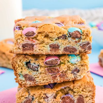 Close up of three easter blondie bars stacked on a pink napkin.