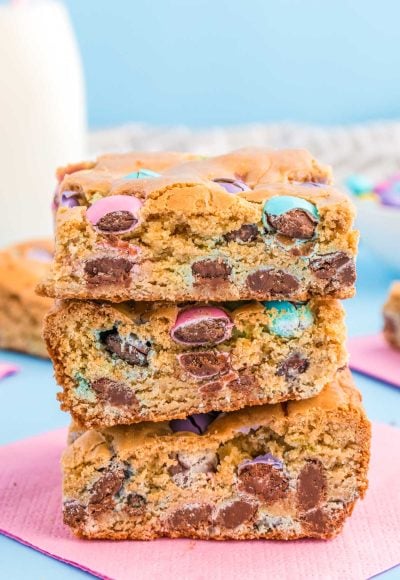 Close up of three easter blondie bars stacked on a pink napkin.