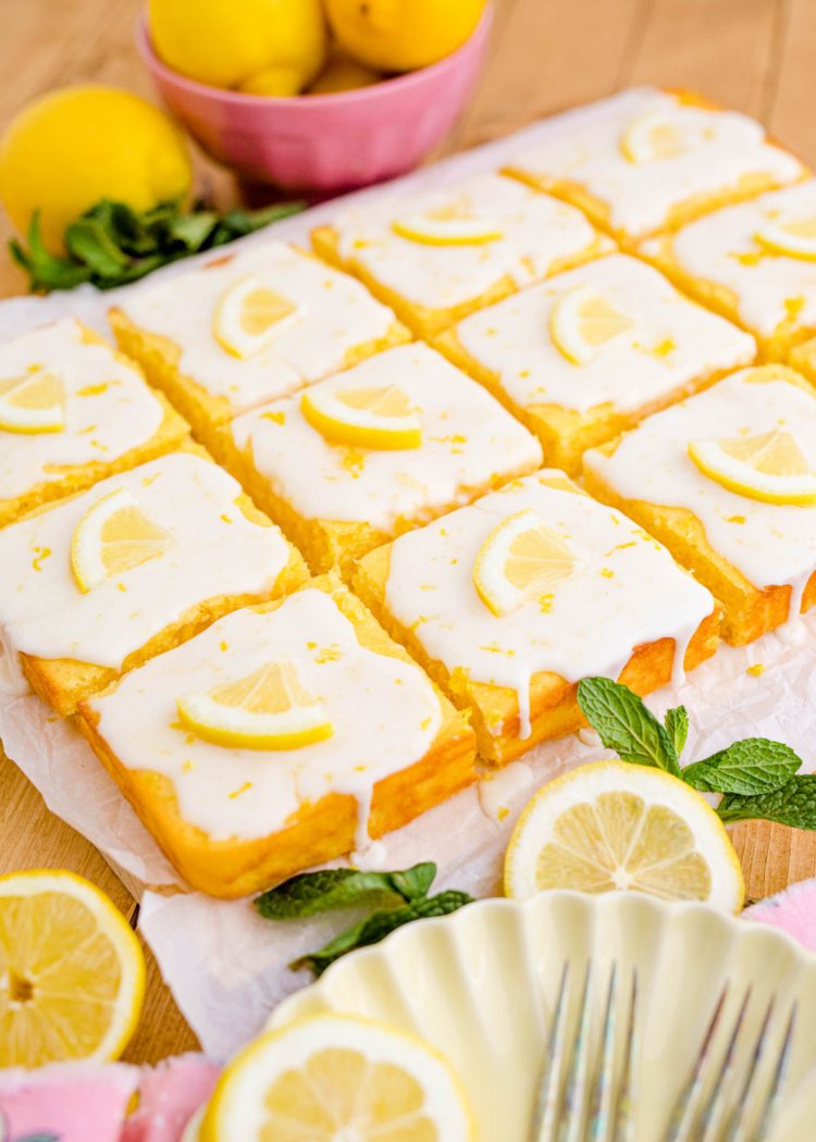 A lemon sheet cake cut into square slices.
