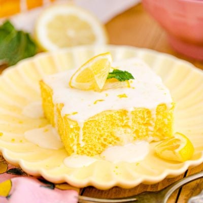 Close up photo of a slice of lemon sheet cake on a yellow plate.