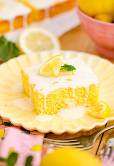 Close up photo of a slice of lemon sheet cake on a yellow plate.