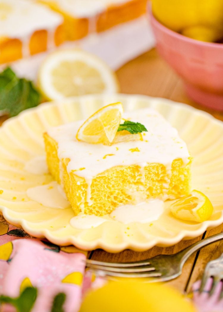 Close up photo of a slice of lemon sheet cake on a yellow plate.