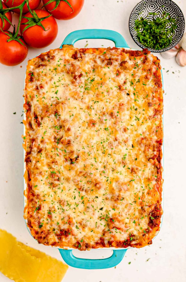 Lasagna in a baking dish on a white table.
