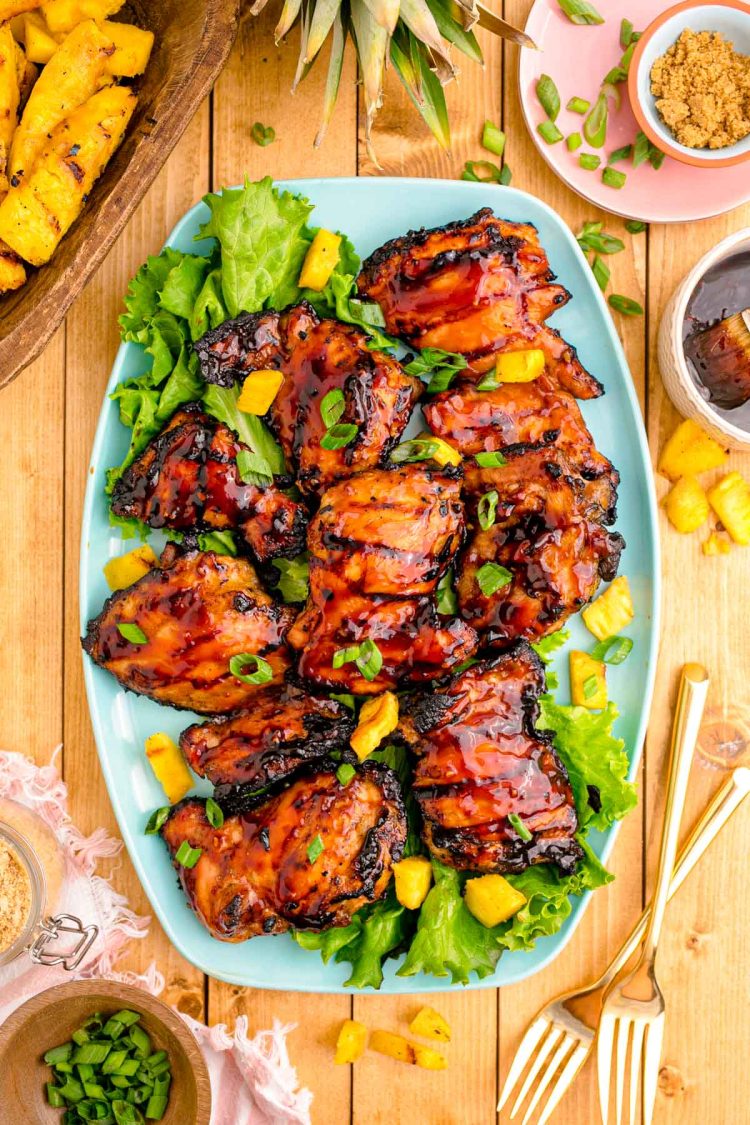 Close up photo of a blue platter with grilled huli huli chicken on it.