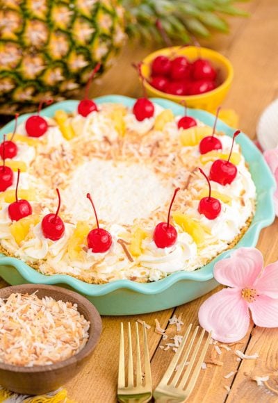 Pina colada pie in a teal pie dish on a wooden table.