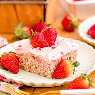 Close up photo of a slice of strawberry sheet cake on a plate.