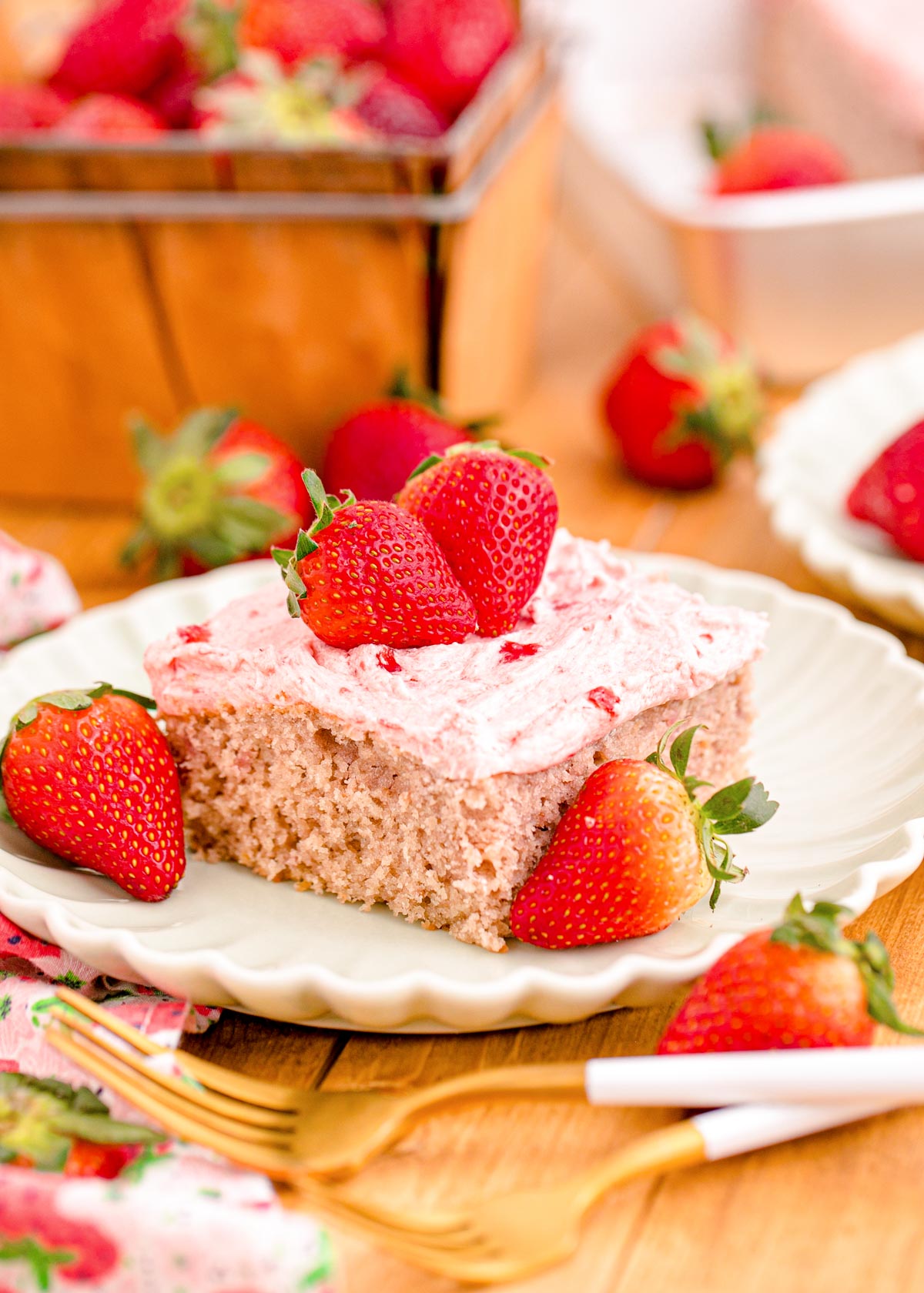 Close up photo of a slice of strawberry sheet cake on a plate.