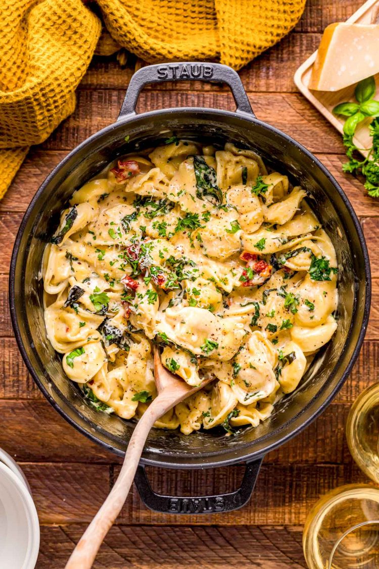 Tortellini Alla Panna in a dutch oven on a wooden table.