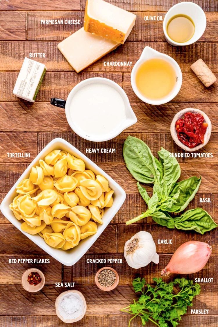 Ingredients to make tortellini alla panna on a wooden table.