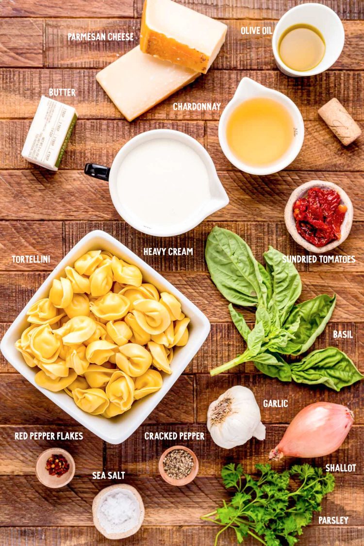 Ingredients to make tortellini alla panna on a wooden table.