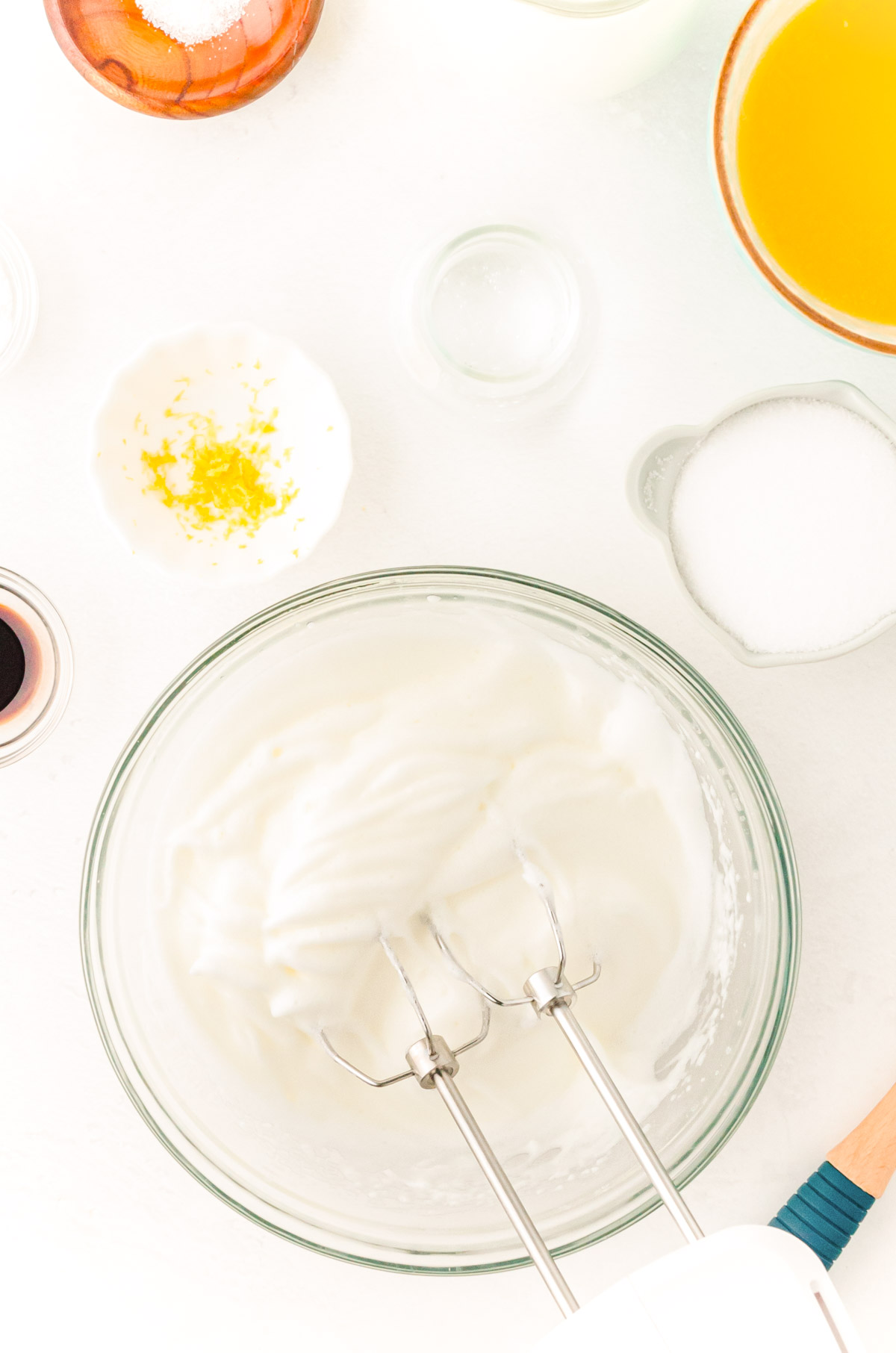 Egg whites being whipped in a glass bowl to make Belgian waffles.