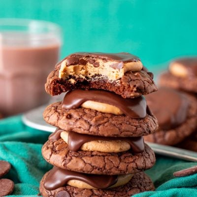 A stack of 4 brownie buckeye cookies on a green napkin.