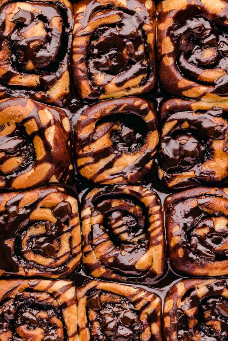 Overhead photo of cinnamon rolls covered in chocolate in the pan.