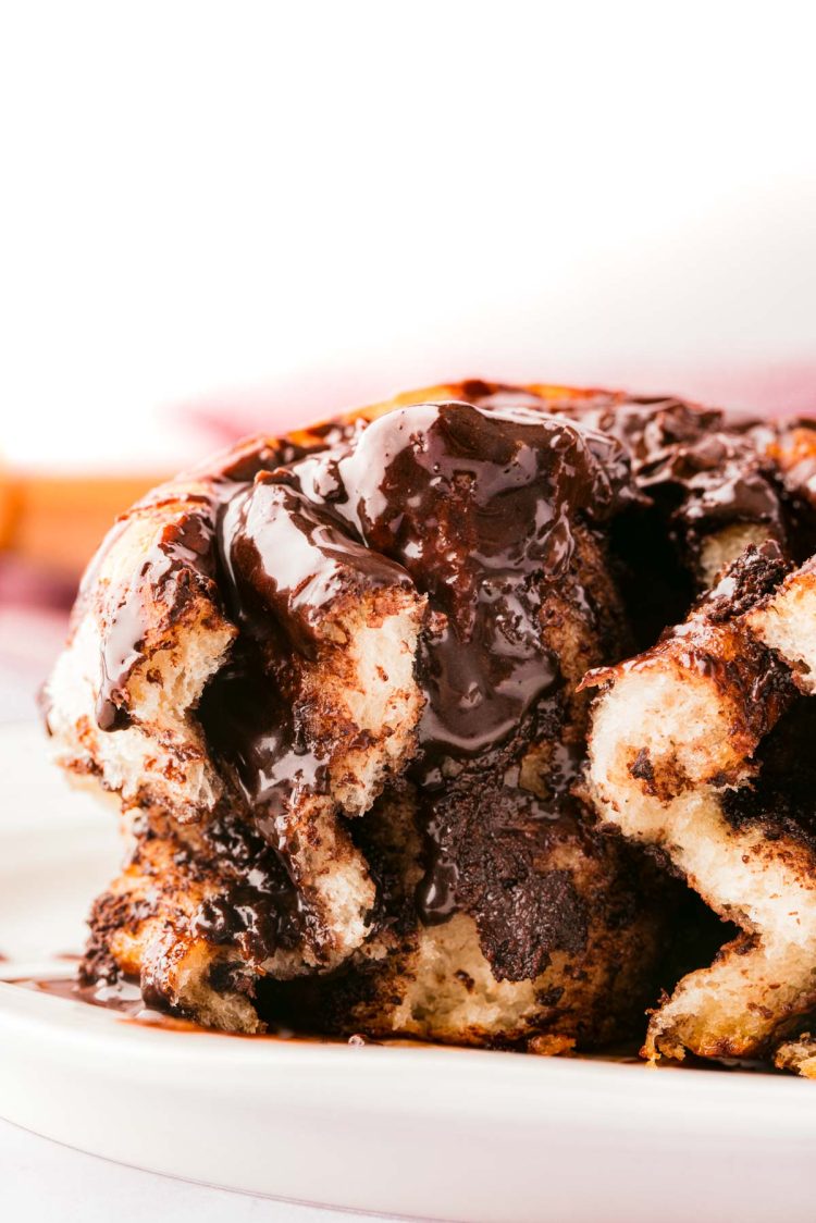 Chocolate cinnamon roll on a white plate showing the center.