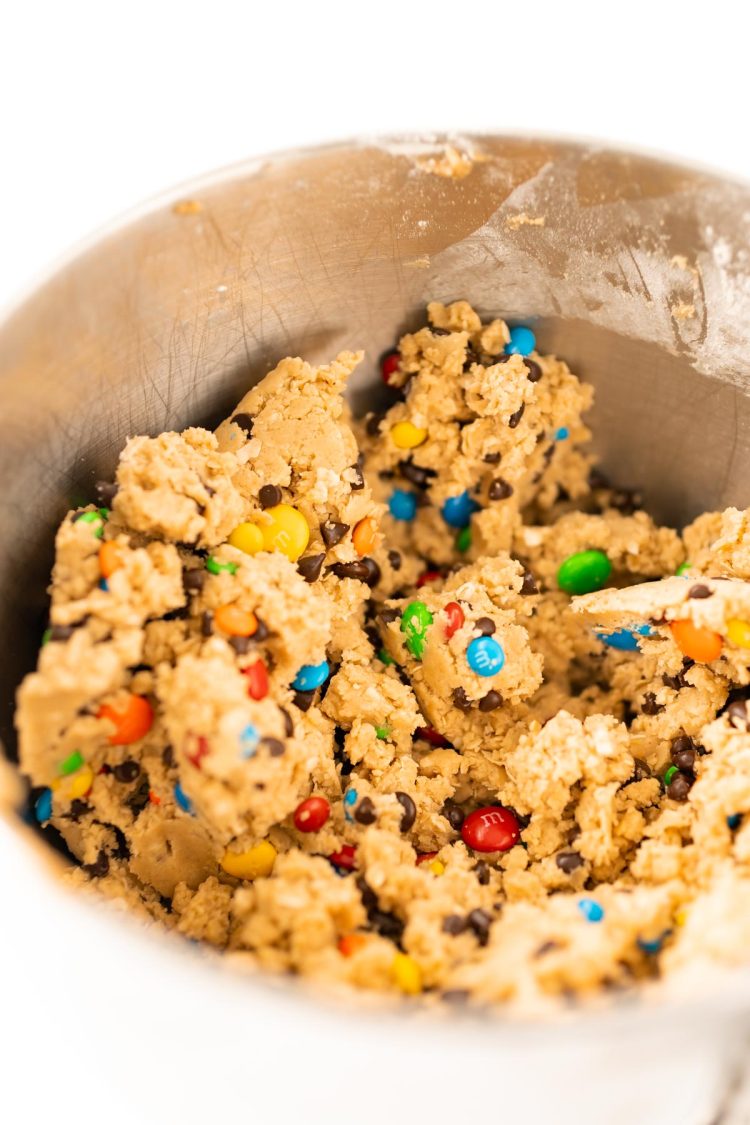 Edible monster cookie dough in a metal mixing bowl.