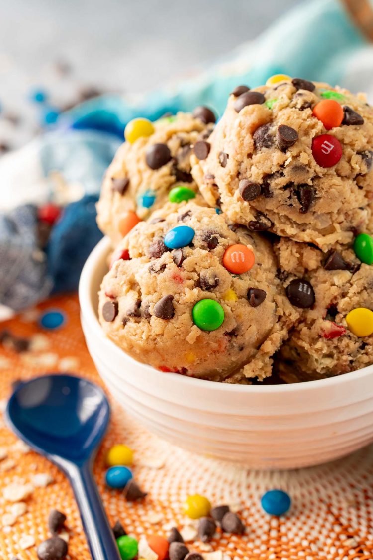 Close up of a white bowl filled with scoops of monster cookie dough.