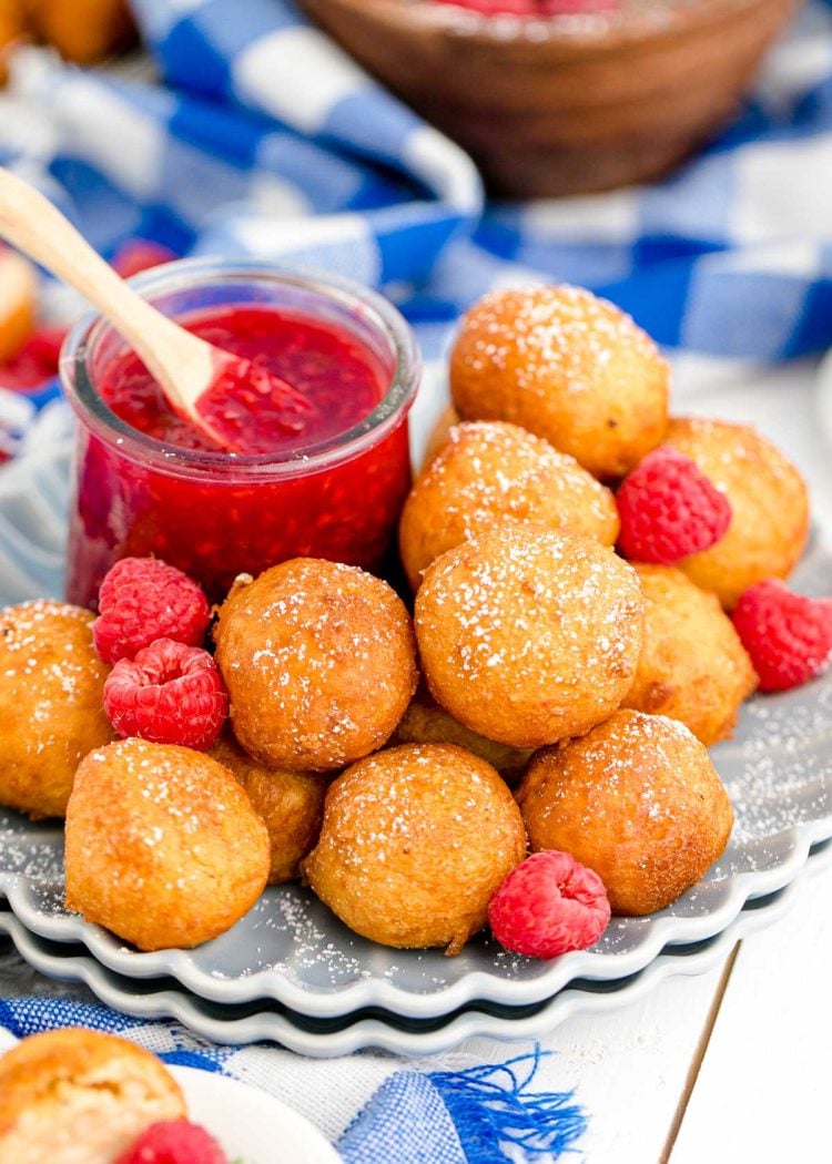 Fried cheesecake bites on a scalloped gray plate.