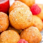 Close up of fried cheesecake balls with raspberries.
