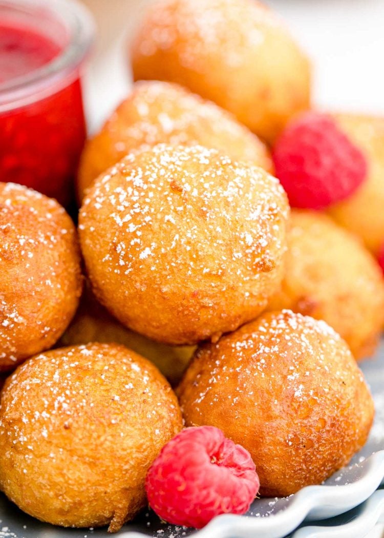 Close up of fried cheesecake balls with raspberries.