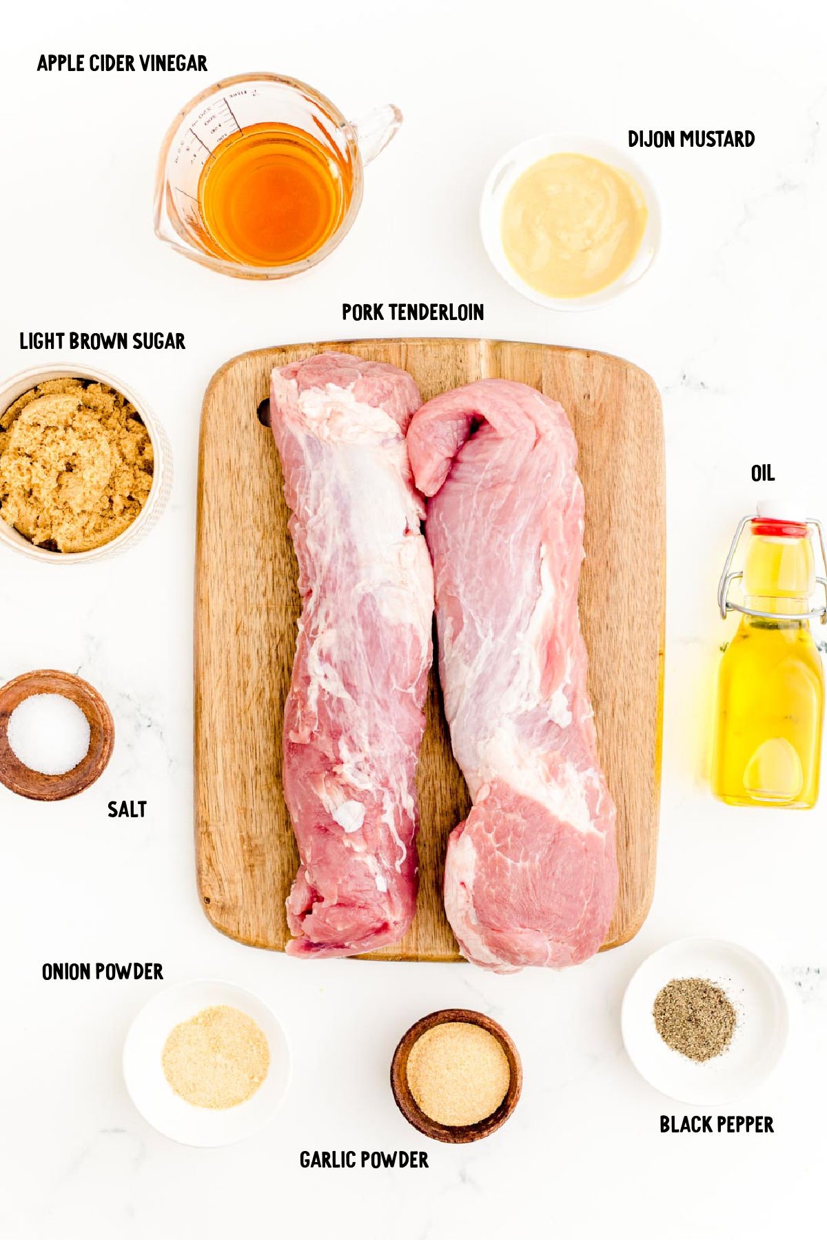 Ingredients to make grilled pork tenderloin prepped on a marble surface.