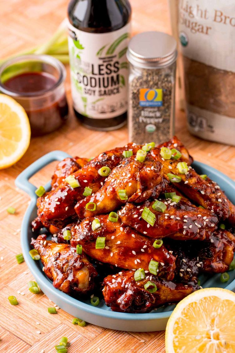 Close up photo of grilled Korean BBQ chicken wings on a blue serving plate.