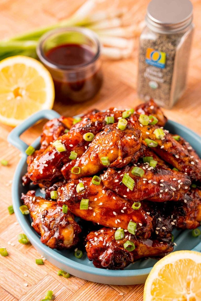 Close up photo of grilled Korean BBQ chicken wings on a blue serving plate.