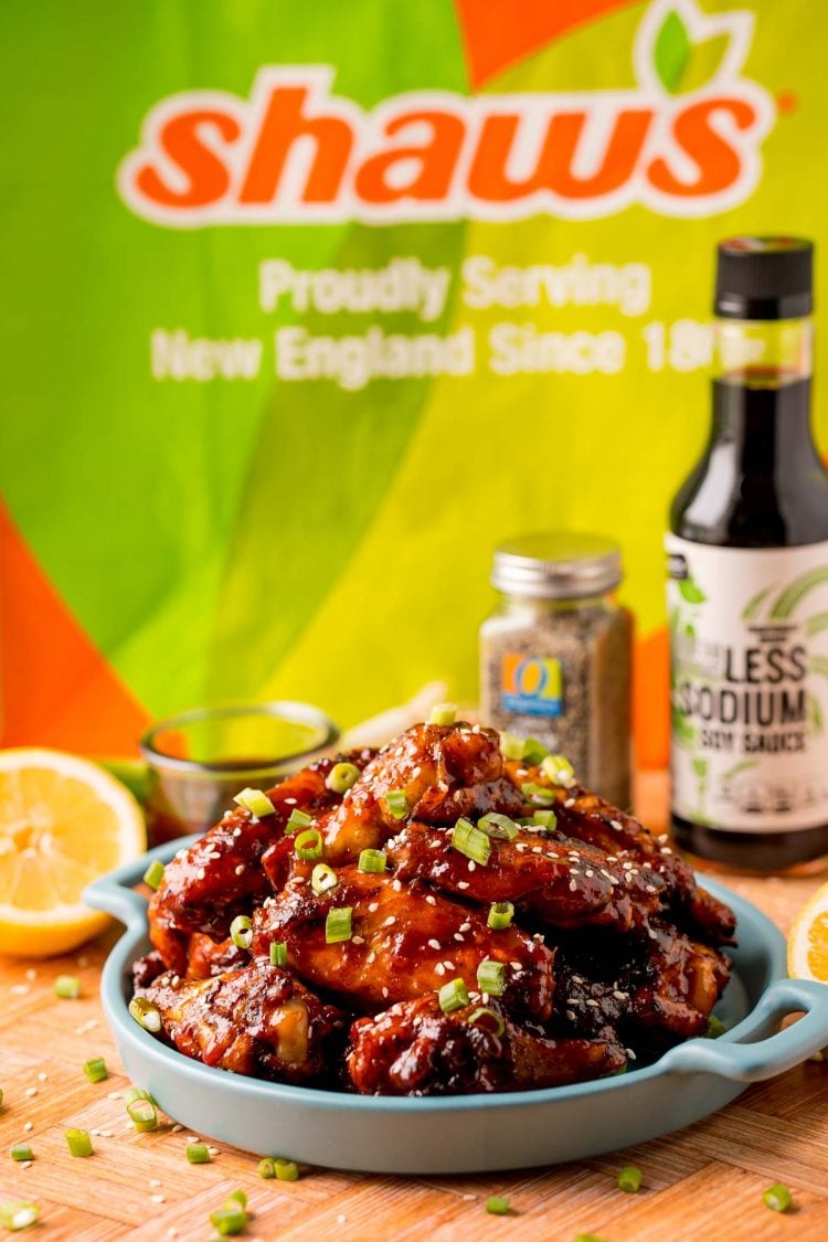 Korean BBQ Chicken Wings on a blue plate with a Shaw's bag in the background.