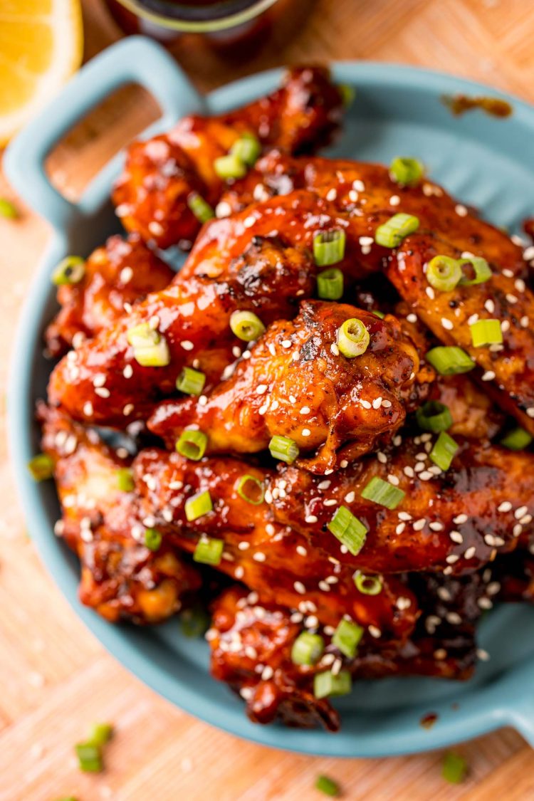 Overhead photo of BBQ wings on a blue plate.