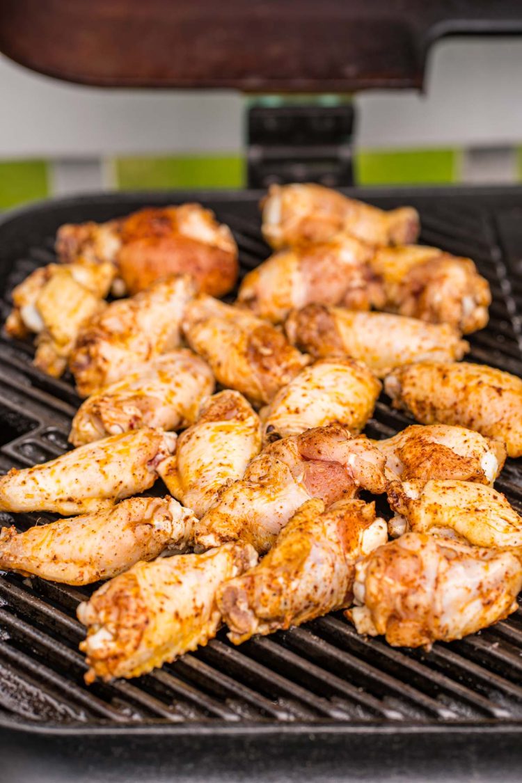 Chicken wings being grilled on a grill.