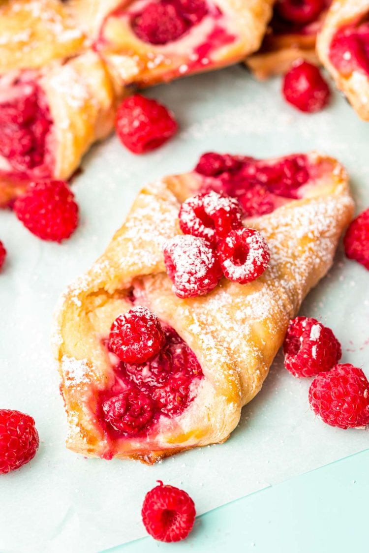 Close up photo of raspberry danish on a piece of parchment paper.