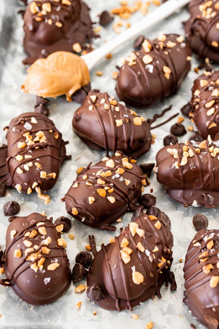 Stuffed dates on a metal tray topped with chopped peanuts.