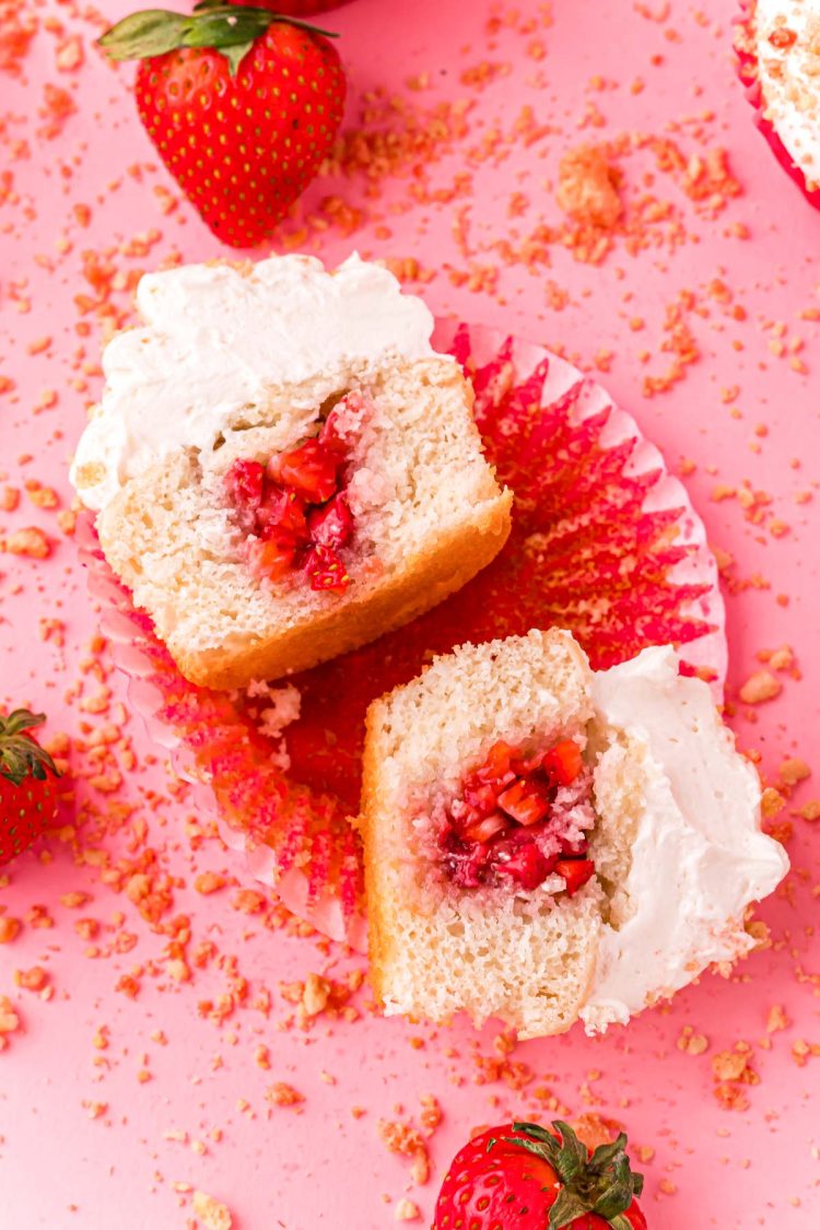 A strawberry filled cupcake that has been cut in half.