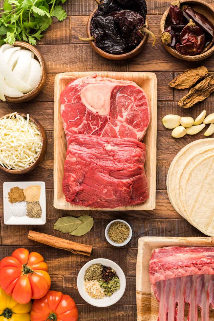 Ingredients to make birria tacos on a wooden table.