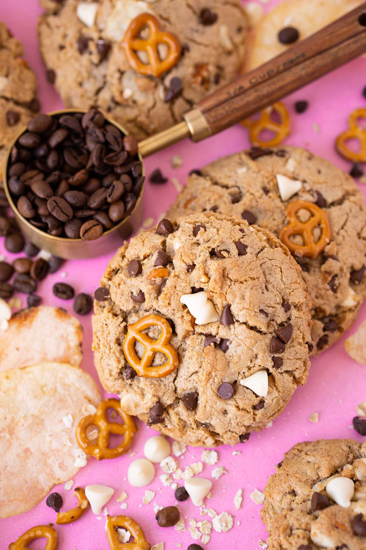 Compost cookies on a pink surface with ingredients around it.